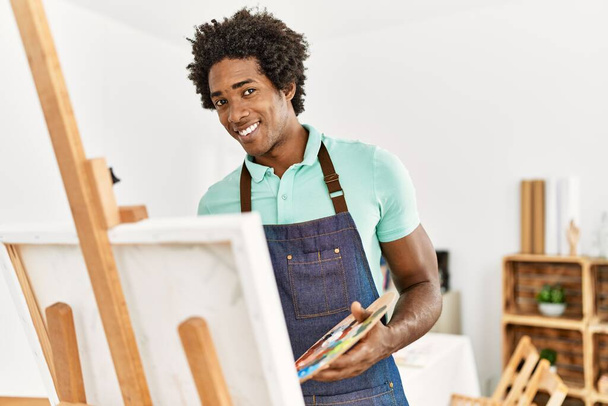 Fiatal afro-amerikai művész férfi mosolyog boldog rajz a művészeti stúdióban. - Fotó, kép