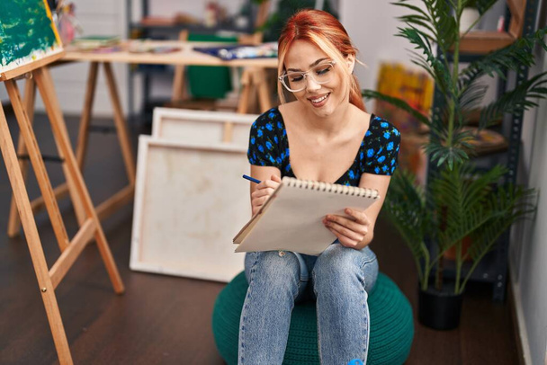 Jeune artiste femme caucasienne souriant dessin confiant sur ordinateur portable au studio d'art - Photo, image
