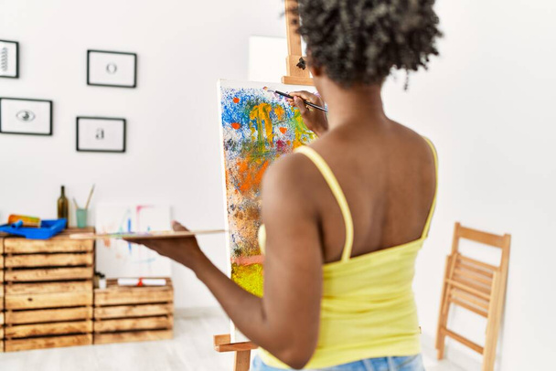 Jovem artista afro-americana mulher na visão traseira desenho no estúdio de arte. - Foto, Imagem
