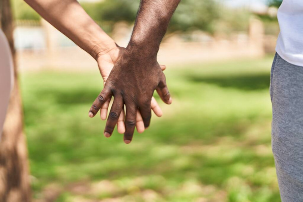 Afrykański amerykański mężczyzna i kobieta para z dłońmi razem w parku - Zdjęcie, obraz