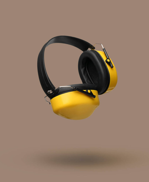 Сучасні слухові протектори на бежевому фоні
 - Фото, зображення