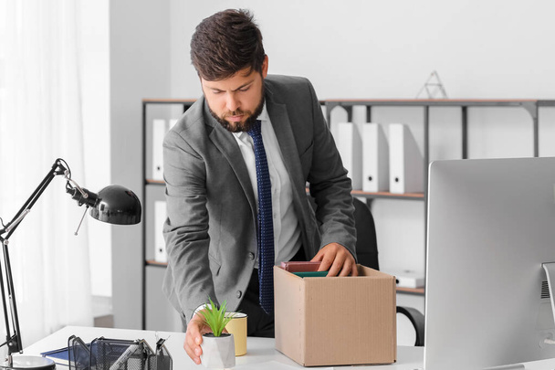 Fired young man packing his stuff in office - Photo, Image