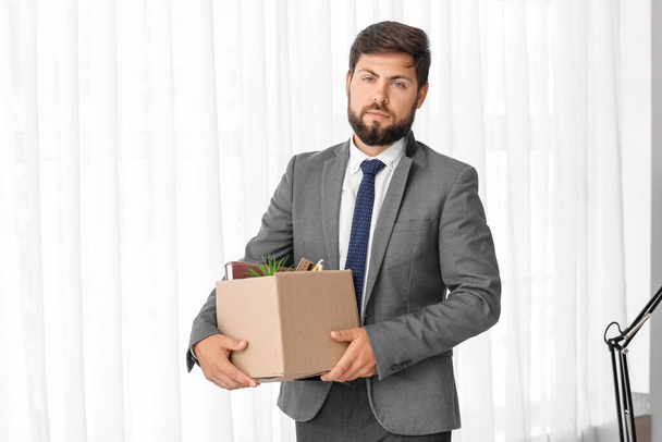 Fired young man holding box with his stuff in office - Photo, Image