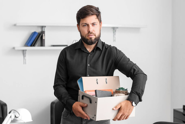Mladý muž s propouštěcím boxem a osobními věcmi v kanceláři - Fotografie, Obrázek