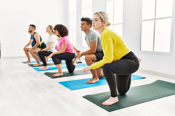 Gruppe junger Leute trainiert konzentriert Yoga im Sportzentrum. - Foto, Bild
