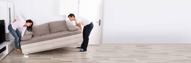 Sofa Lifting Pain. Young Couple Move Furniture - Foto, afbeelding