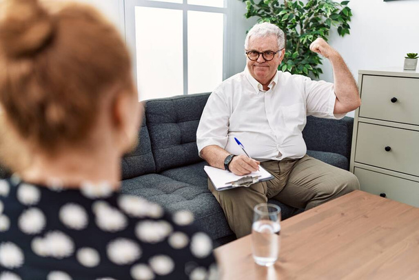 Psicologo anziano uomo all'ufficio di consultazione persona forte che mostra muscoli del braccio, fiducioso e orgoglioso del potere  - Foto, immagini