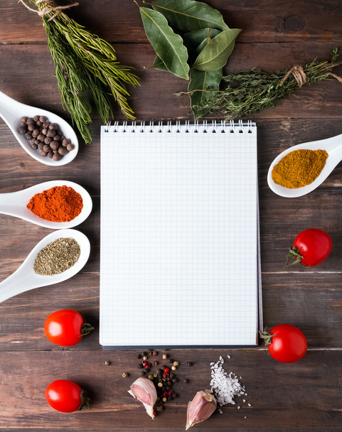 Fresh herbs, spices and notebook on the wooden table - Photo, image