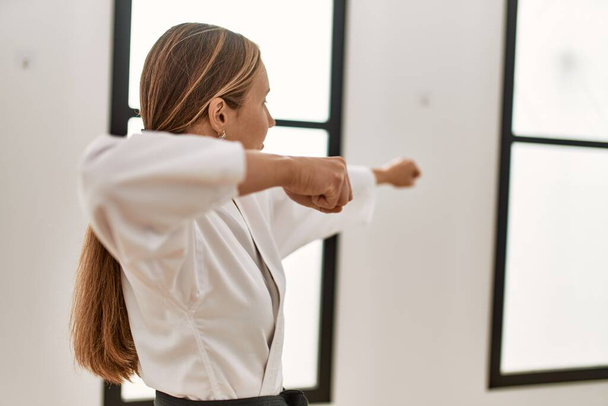 Young caucasian woman training karate at sport center - Foto, Imagem