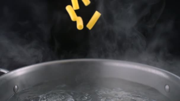 Throwing tortiglioni pasta into boiled water - Footage, Video