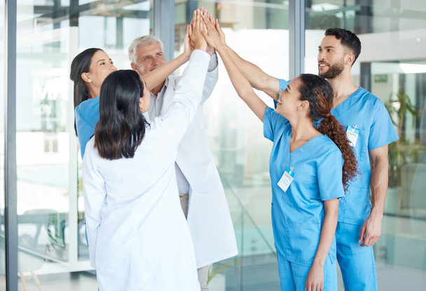 Providing motivation in these trying times. a team of medical staff high fiving one another - Photo, Image