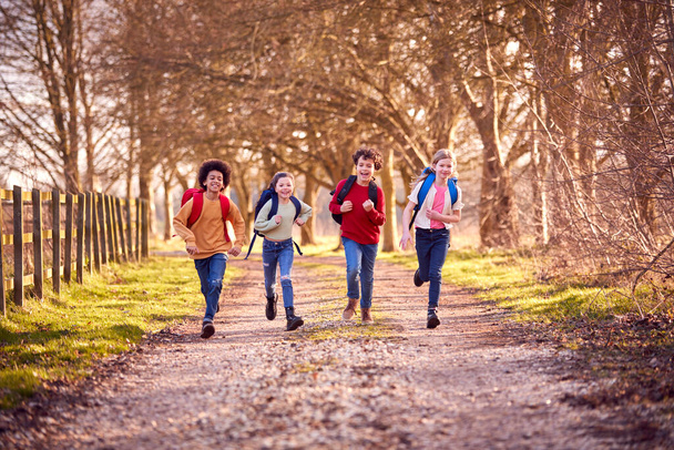 Portrait Children With School Backpacks Outdoors Running Along Countryside Track - Photo, Image