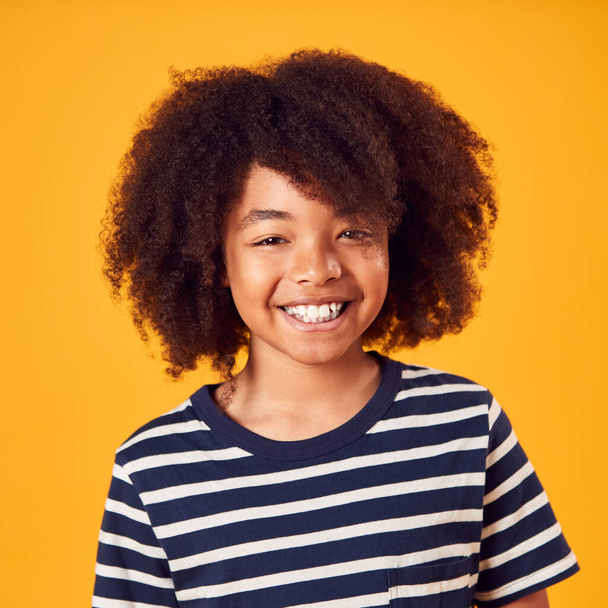 Studio Portrait Of Smiling Young Boy Shot Against Yellow Background - Фото, изображение