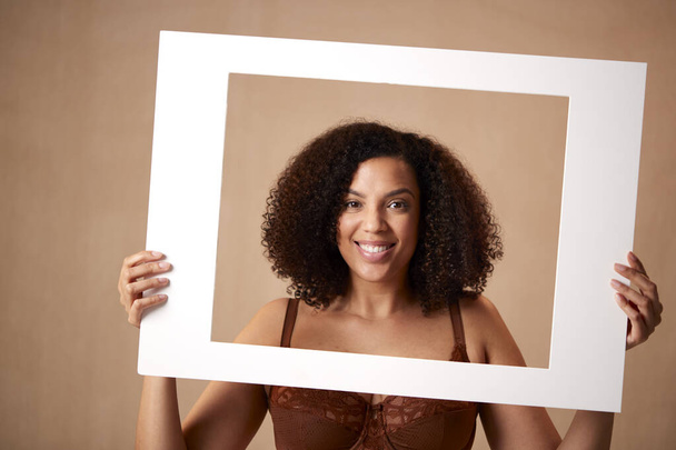 Studio Shot Of Confident Natural Woman In Underwear Promoting Body Positivity In Picture Frame - Photo, image