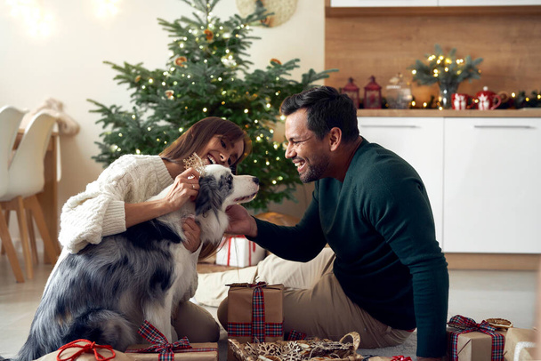 Multi pareja étnica pasar tiempo con el perro en Navidad  - Foto, imagen