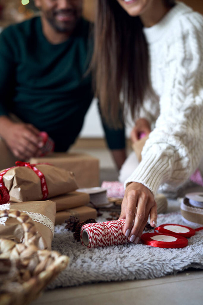 Couple choisissant ruban pour cadeau de Noël à la maison  - Photo, image