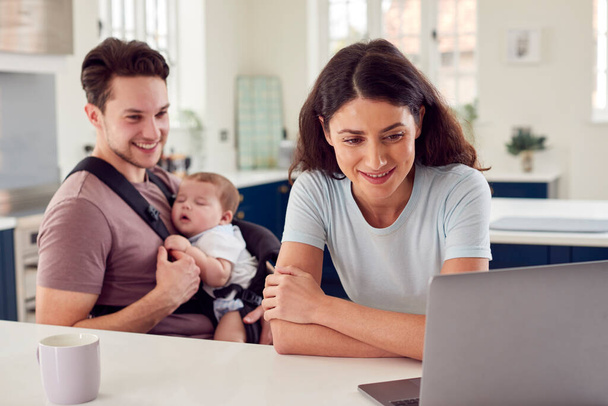 Transgender Family With Baby Working From Home Looking At Laptop On Kitchen Counter - Zdjęcie, obraz
