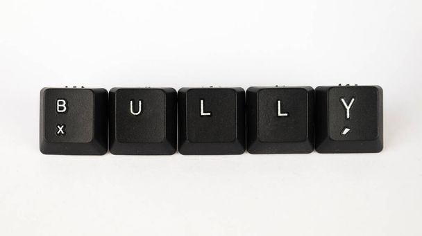 Cyberbullying szöveg létre billentyűzet kulcsok elszigetelt fehér háttér, szociális média terminológia, fehér zsarnok fekete billentyűzet, felső nézet - Fotó, kép