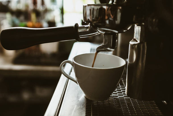Espressomaschine in der Cafétheke mit frisch gebrühtem Kaffee. Kaffeemaschinen-Konzept. - Foto, Bild