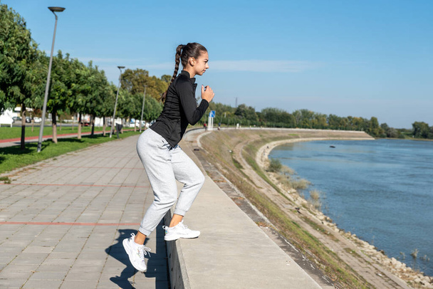 Young school or college university student fit teen girl morning routine of exercising outdoor. Fitness female morning workout training for healthy life before study time. - Foto, Imagem