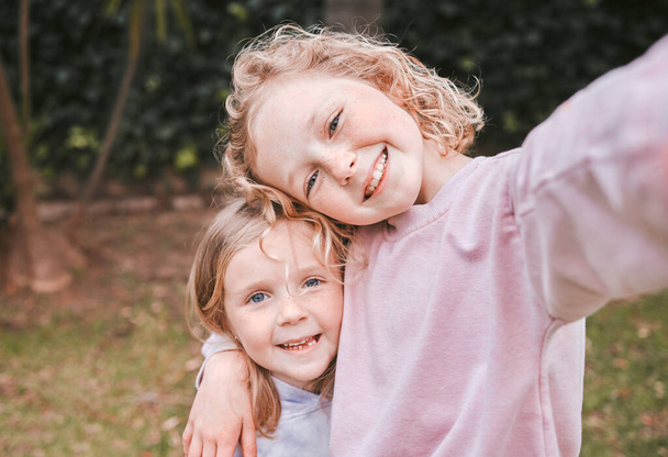 Wer braucht schon Spielzeug, wenn man glückliche Kindheitserinnerungen hat. zwei entzückende kleine Mädchen machen Selfies im Garten - Foto, Bild