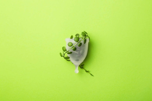 Menstrual cup and green leaves. Sustainable period, zero waste. - Photo, Image