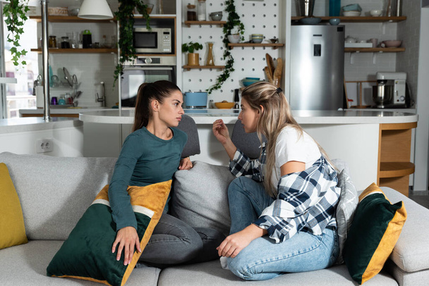 Young women lesbian couple LGBTQ+ roommates having argue due the infidelity and cheating. Two girls in relationship having difficulty caused by jealousy. Marriage problems concept. - Foto, Imagen