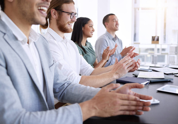 Comparte tus conocimientos con el equipo. un grupo diverso de empresarios sentados juntos y aplaudiendo después de una presentación en la oficina - Foto, imagen