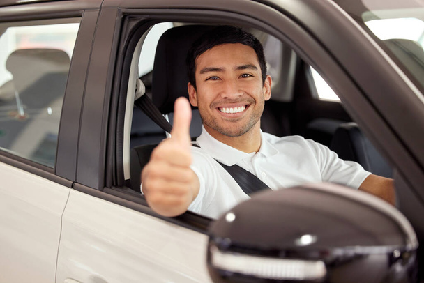 Viajes seguros. un hombre mostrando los pulgares hacia arriba mientras está sentado en su nuevo coche - Foto, Imagen