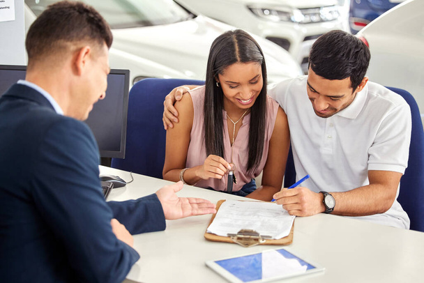 Su financiación ha sido aprobada. una joven pareja consultando con un vendedor de coches - Foto, imagen
