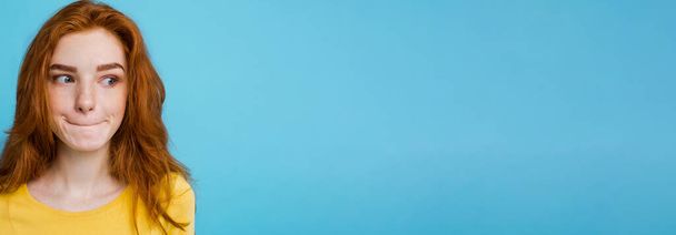 Headshot Ritratto di felice ragazza capelli rossi zenzero con lentiggini sorridente guardando la fotocamera. Sfondo blu pastello. Copia spazio. - Foto, immagini