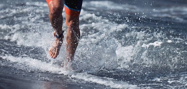 Тріатлоніст плаває з океану, закінчуючи плаванням. Вмістити людину, що закінчує плавання спринтер, визначений з води
 - Фото, зображення