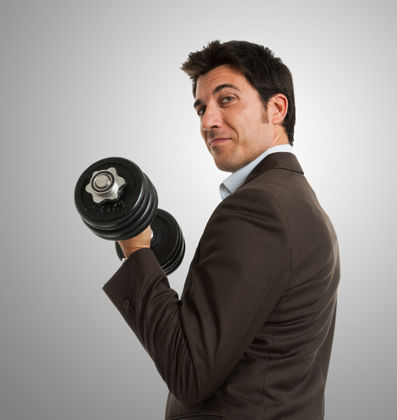 Businessman lifting a dumbbell - Foto, afbeelding