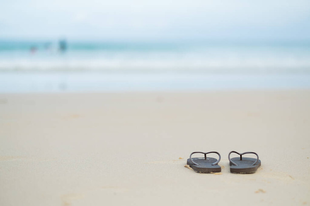 παπούτσια στην άμμο με φόντο τη θάλασσα, χαλαρώστε φόντο, ωραία ocea - Φωτογραφία, εικόνα