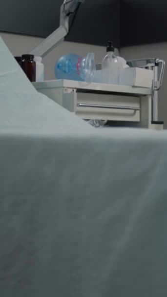 Vidéo verticale : Gros plan du moniteur de fréquence cardiaque dans la salle d'hôpital vide avec du matériel médical pour les soins de santé. Personne dans la salle de réanimation pour blessure d'urgence ou réanimation et soins intensifs. - Séquence, vidéo
