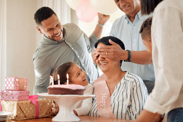 Mi ebben a meglepetés? Egy család meglepi az anyjukat egy szülinapi tortával otthon. - Fotó, kép