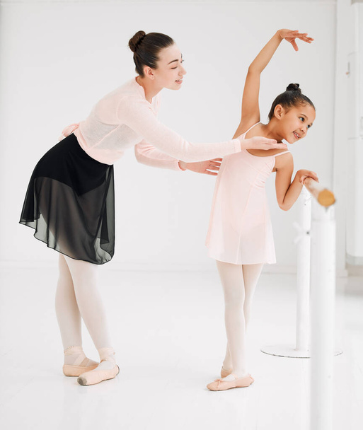 Pamiętaj, żeby kontrolować swoją twarz. mała dziewczynka ćwicząca balet ze swoim nauczycielem w studiu tańca - Zdjęcie, obraz