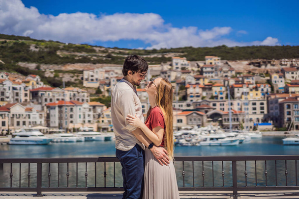 Couple in love tourists enjoying the views of Architecture and luxury yachts in Lustica Bay, Montenegro. Travel around Montenegro concept. Go Everywhere. - Foto, Imagen