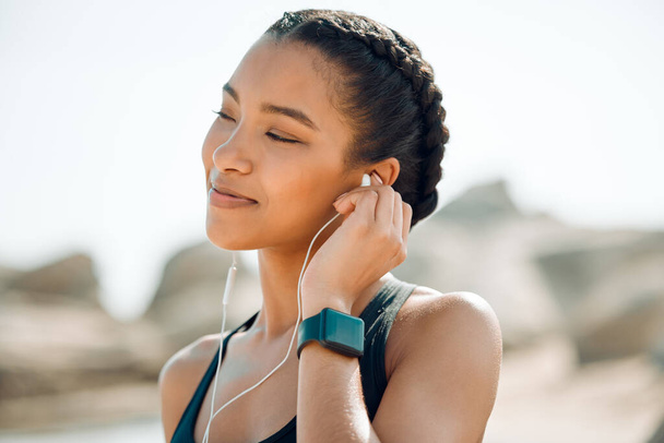 This song is like water on my soul. a young woman listening to music during a workout - Photo, Image