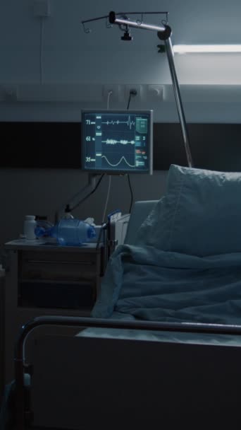 Vertikální video: Prázdné pohotovostní nemocniční oddělení ozdobené zdravotnickým vybavením, lůžkem, monitorem, počítačem, invalidním vozíkem. Reanimační místnost pro léčení nemocí, zotavení z chirurgických zákroků, klinická - Záběry, video