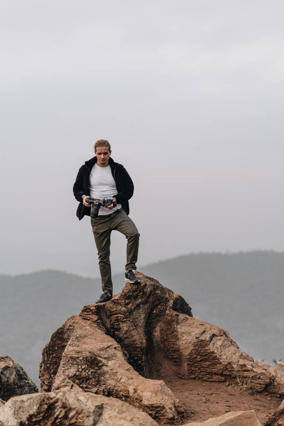 Man is standing on a high viewpoint with video camera. High quality photo - Foto, Imagen