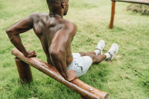 Noir homme faisant triceps trempette exercice sur un banc.. Photo de haute qualité - Photo, image