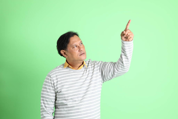 40s dospělý nadváha Asiat muž stojící na zeleném pozadí. - Fotografie, Obrázek