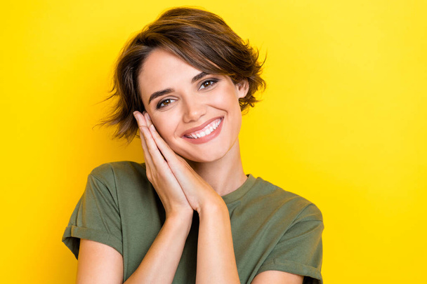Photo of nice gorgeous sweet pretty girl with bob hairstyle wear khaki t-shirt palms on cheekbone isolated on yellow color background. - Foto, Imagen