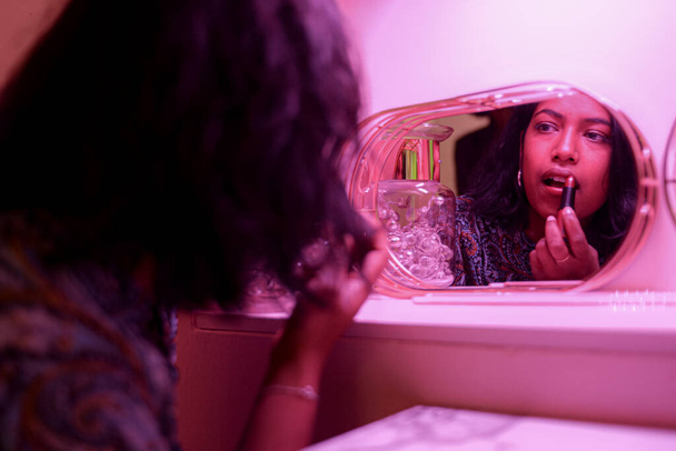 barna fiatal nő modell tesz rúzs reflceting a tükör - Fotó, kép