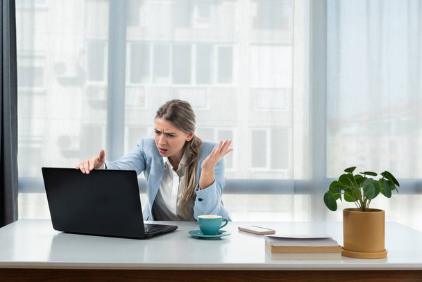 Frustrated annoyed woman confused by computer problem, annoyed businesswoman feels indignant about laptop crash, bad news online or disgusting video on web, stressed student looking at broken pc - 写真・画像