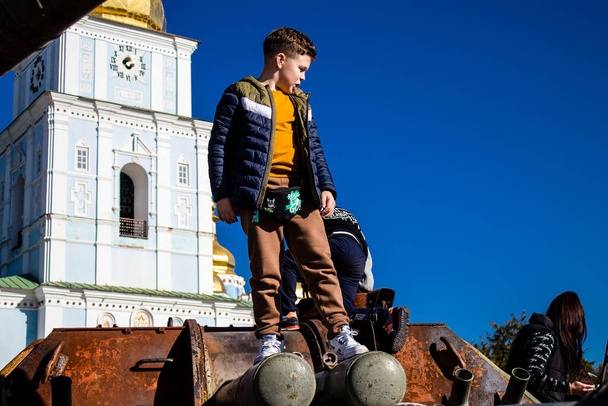 Zničená výstava ruského vojenského vybavení na Mykhailivském náměstí na Kyjevě na Ukrajině, 16. října 2022Ukrajinské děti se baví na zničeném ruském vojenském vybavení, používají ho jako dětské hřiště. - Fotografie, Obrázek