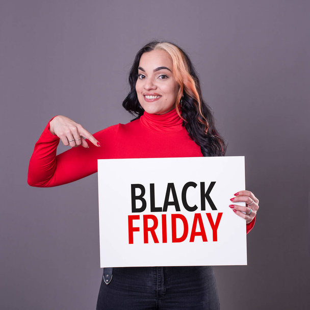 Schöne Frau zeigt auf ein Black-Friday-Schild - Foto, Bild