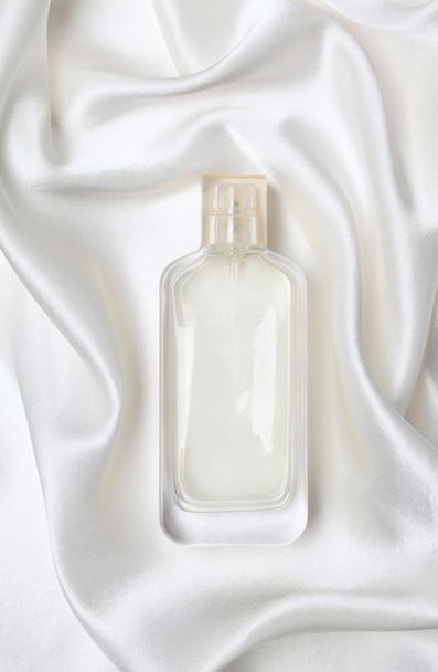 White perfume bottle on the silk. - Foto, imagen
