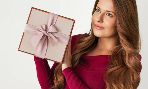Holiday present for birthday, baby shower, wedding or luxury beauty box subscription delivery, happy woman holding a wrapped pink gift on white background - Photo, image